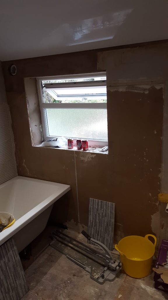 New bathroom part-way through installation with plumbing and tiling under way